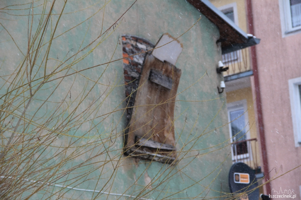 Niebezpieczna płyta wisi na budynku