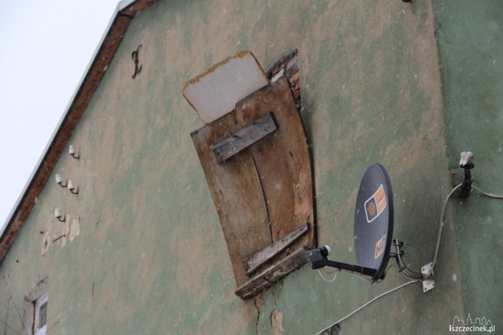 Niebezpieczna płyta wisi na budynku