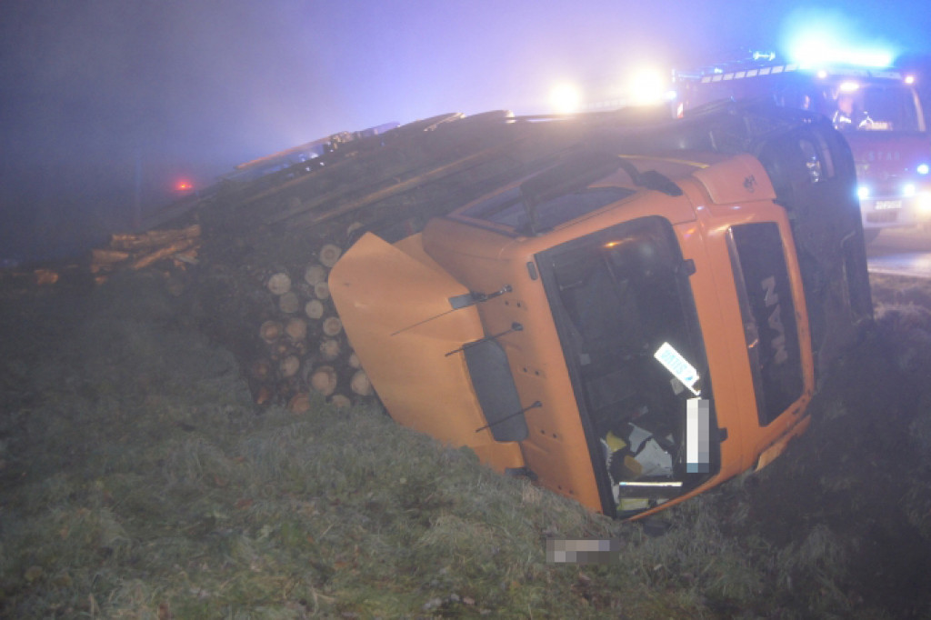 Ciężarówka z drewnem przewróciła się na bok