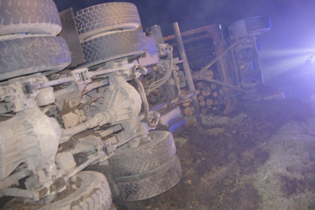 Ciężarówka z drewnem przewróciła się na bok