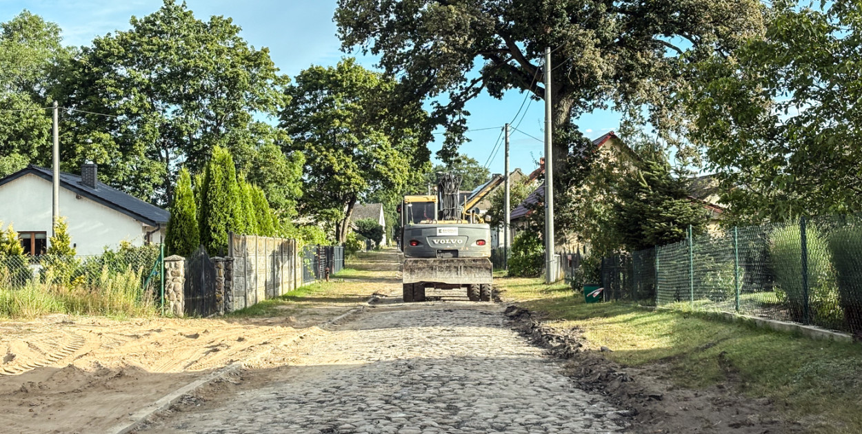 fot. iszczecinek.pl / Droga w Sporem w trakcie przebudowy, odsłonięta stara kostka brukowa i ciężki sprzęt.